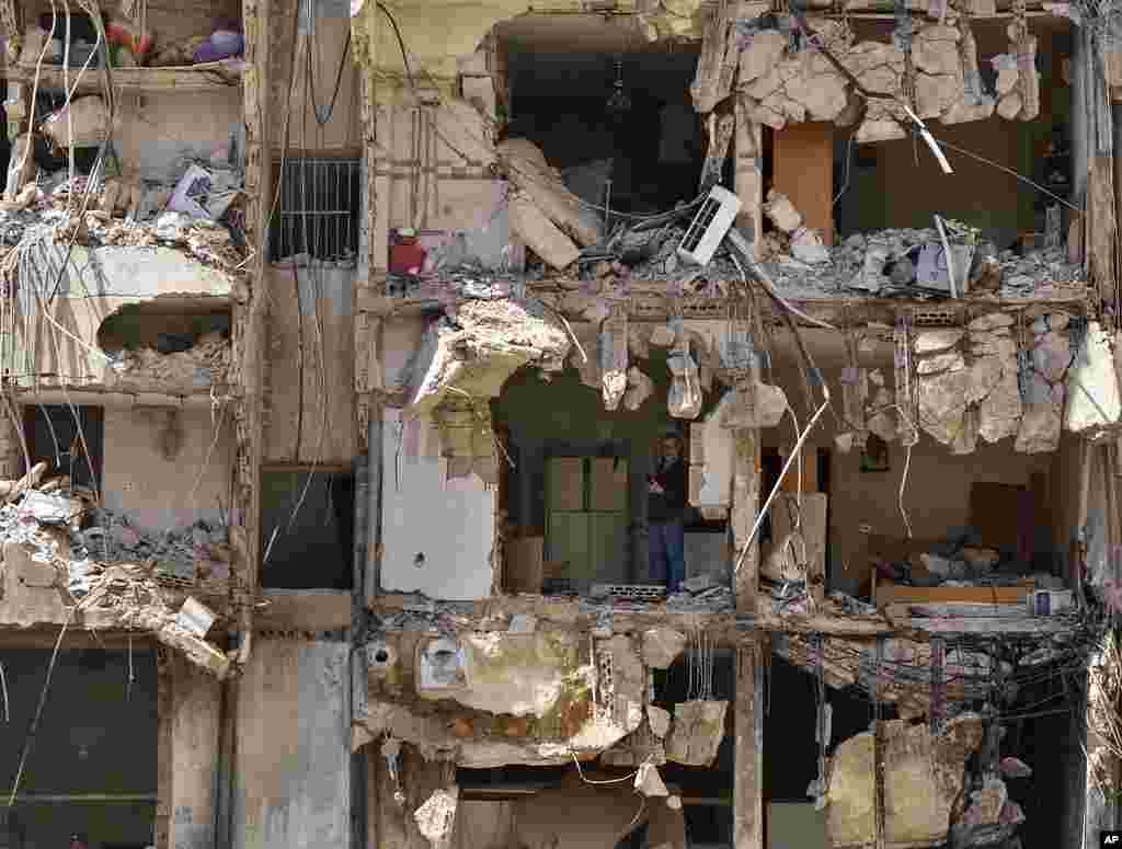 A man watches rescuers sift through the rubble as they search for people still missing at the site of Friday&#39;s Israeli strike in Beirut&#39;s southern suburbs, Lebanon.