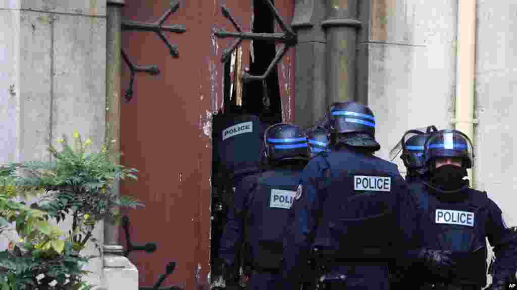 Des policiers français défoncent l&rsquo;entrée d&rsquo;une église au cours d&rsquo;un raid dans la banlieue parisienne, Saint-Denis, 18 novembre 2015.