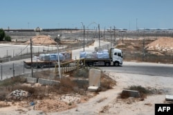 A truck carrying humanitarian aid for the Gaza Strip drives at the Kerem Shalom border crossing between southern Israel and Gaza, on June 17, 2024.