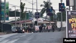 FILE — Hooded armed men in military fatigues stand on a street after unidentified gunmen attacked military barracks and attempted to break into an armory at Congo Cross roundabout in Freetown, Sierra Leone November 26, 2023.