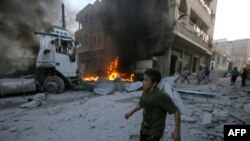 A boy runs past a fire started in a building following a reported airstrike by Syrian regime forces in the town of Maaret al-Numan in Syria's northwestern Idlib province, Aug. 28, 2019. 