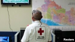Yon manm Lawwa Wouj nan Salvadò ap swiv yon ekran aprè yon tranblemanntè 7. 4 frape kòt pasifik peyi a. (Foto: REUTERS/Jose Cabezas).