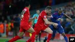 Jordan Henderson de Liverpool, au centre, en duel avec Ashley Young de Manchester, à droite, au cours d’un match de la Premier League anglaise au stade d’Anfield à Liverpool, Angleterre, 10 octobre 2016.