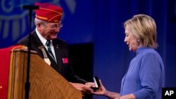 American Legion National Commander Dale Barnett presents an award to Democratic presidential candidate Hillary Clinton after she spoke at the American Legion's 98th Annual Convention at the Duke Energy Convention Center in Cincinnati, Ohio, Aug. 31, 2016.