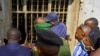 Congolese security officers look at a broken window at the Kangbayi central prison in Beni, Democratic Republic of Congo, October 20, 2020. 