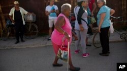 Pura Castell walks to a government-run butcher shop to buy chicken, after failing to find chicken the previous day in Bauta, Cuba, April 12, 2019.