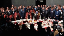 FILE - Armenian officials lay flowers at a monument to the victims of mass killings by Ottoman Turks, to commemorate the 103rd anniversary of what they consider genocide against Armenians, in Yerevan, April 24, 2018. 