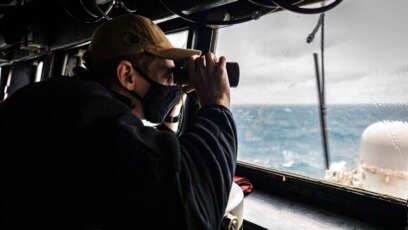 Dalam foto yang dirilis oleh Angkatan Laut AS ini, Letnan Muda Grayson Sigler melakukan obersvasi dari kapal perang USS John S. McCain dalam sebuah patroli kawasan Indo-Pasifik di Selat Taiwan pada 30 Desember 2020. (Foto: US Navy via AP)