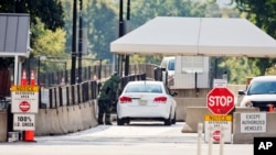 An explosive technician in a bomb suit approaches a vehicle near the entrance to White House in Washington, Sept. 20, 2014. 