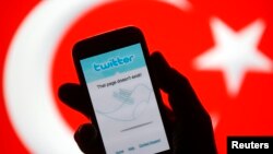 FILE - A person holds a Samsung Galaxy S4 displaying a Twitter error message in front of Turkish national flag in this illustration taken in Zenica, March 21, 2014. 