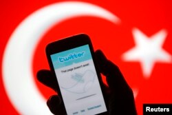 FILE - A person holds a Samsung Galaxy S4 displaying a Twitter error message in front of Turkish national flag in this illustration taken in Zenica, March 21, 2014.