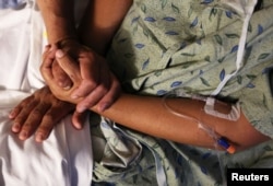 지난해 미국 애리조나주 투손의 병원에서 환자의 손을 보호자가 잡고 있다. (자료사진)