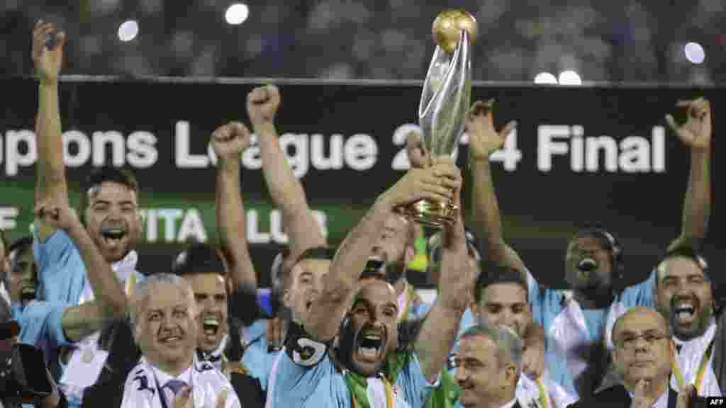 Farid Mellouli d'Entente Sportive de Sétif en Algérie (C) célèbre avec le trophée après avoir remporté le match de football finale de la Ligue africaine des champions contre l'AS Vita Club de la République démocratique du Congo, au stade Mustapha Tchaker à Blida 