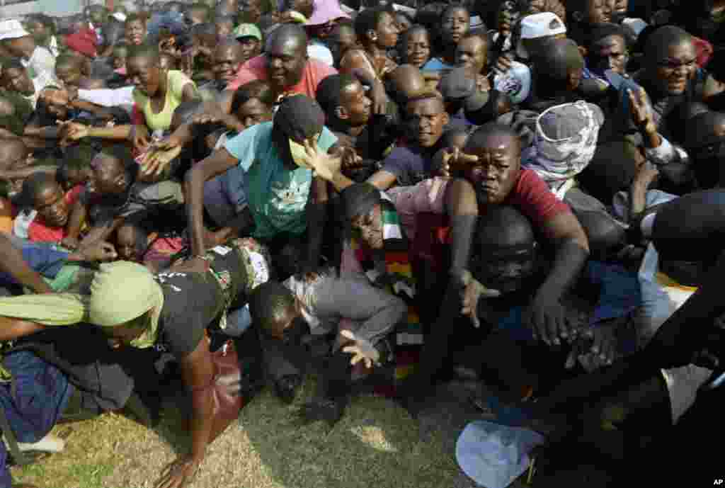 People rush after the arrival of the coffin carrying former President Robert Mugabe at the Rufaro Stadium in Harare, where Mugabe will lie in state for a public viewing.