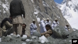 Pakistan army soldiers involved in a rescue work along with locals at the scene of a massive avalanche which buried 140 people including 129 Pakistani soldiers last week at the Siachen glacier in Pakistan, April 18, 2012.