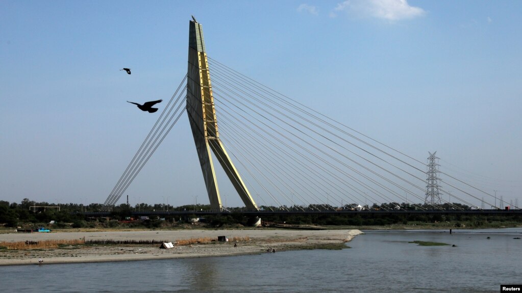 2020年4月22日地球日印度新德里: 冠状病毒病封锁期间空气污染下降，鸟飞印度过亚穆纳河Signature大桥。