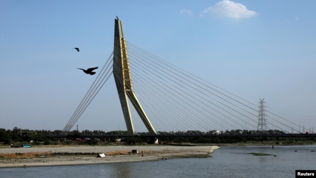 Aves vuelan sobre las aguas del río Yamuna después que el nivel de contaminación del aire comenzó a disminuir tras la cuarentena por el coronavirus en Nueva Delhi, India, el 22 de abril de 2020.