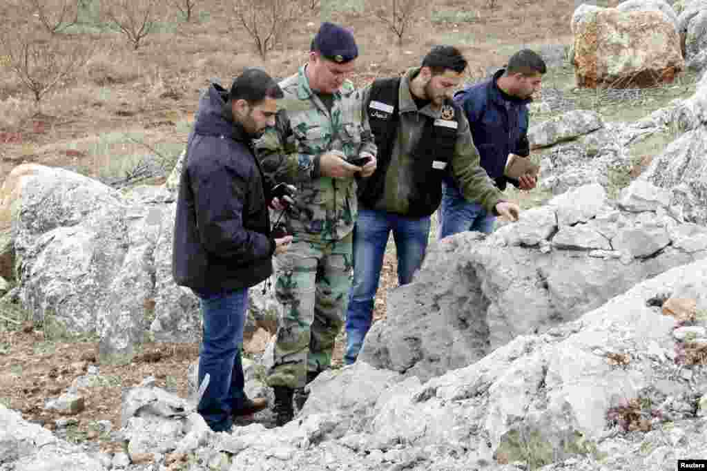 Lebanese army personnel inspect the remains of a shell that was launched from Lebanon to Israel. According to activists, the shell landed about 500m from the Lebanese-Israeli border, Sarada, Lebanon, Dec. 29, 2013.&nbsp;