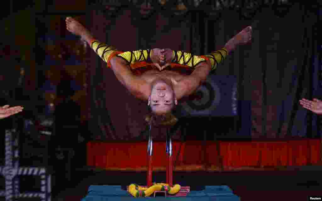 A performer balances himself on a set of knives during a special preview as part of Christmas celebrations at the Ajanta circus in Kolkata, India.