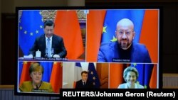 European Commission President Ursula von der Leyen, European Council President Charles Michel, German Chancellor Angela Merkel, French President Emmanuel Macron and Chinese President Xi Jinping are seen on a screen during a video conference, in Brussels, Belgium December 30, 2020