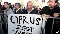 Protesters stand during parliamentary vote on a bank tax plan March 19, 2013 in Nicosia