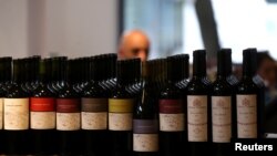 A man is seen behind bottles of wine inside a wine store in Buenos Aires, Argentina, Nov. 8, 2017.