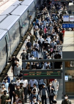 Para penumpang turun dari kereta api di Stasiun Seoul, Korea Selatan, 11 Juni 2020.