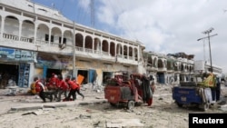 Rescuers carry an unidentified injured man from the scene of an explosion in front of Dayah hotel in Somalia's capital Mogadishu, Jan. 25, 2017.