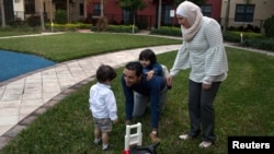 Temporary Protected Status (TPS) holders Mohammad Alala and his wife, Dania, both from Syria, and their two U.S.-born children, Taim and Amr play, at a playground at their home in Miramar, Florida, Jan. 24, 2018. 