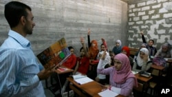 FILE - A Syrian teacher (L) is seen teaching at a school built for Syrian refugees in the southern port city of Sidon, Lebanon.