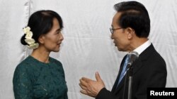 Presiden Korea Selatan Lee Myung-bak (kanan) berjabata tangan dengan Aung San Suu Kyi setelah jumpa pers di Sedona Hotel di Yangon (15/5).