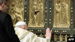 Pope Francis (R) opens the Holy Door of St Peter's Basilica, during a special ceremony to mark the launch of the Jubilee 2025, a year of Catholic celebrations set to draw more than 30 million pilgrims to Rome, at the Vatican, on Dec. 24, 2024.