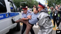 Kazakh police detain a demonstrator in Almaty, Kazakhstan, June 12, 2019, during protests against presidential elections.