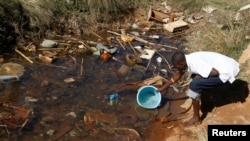 FILE: Residences of Mabvuku fetch water from unproteacted sources in Harare, Zimbabwe, July 28, 2012.