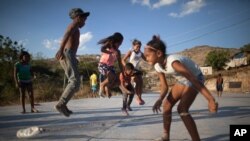 Niños saltan una cuerda mientras juegan en una cancha cercana al basurero de Pavía en Barquisimeto, Venezuela, miércoles 3 de marzo de 2021.