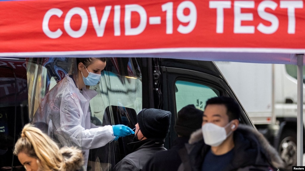 A man is tested for the coronavirus disease (COVID-19) at a mobile COVID-19 testing unit, as pedestrians make their way in the sidewalk during the spread of the Omicron coronavirus variant in Manhattan, New York, U.S., December 8, 2021. (REUTERS/Eduardo Munoz/File Photo)