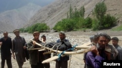 Warga membawa korban banjir di distrik Gozargah-e Noor provinsi Baghlan 7 Juni 2014. 