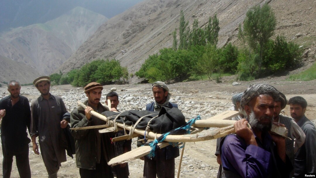 Warga membawa korban banjir di distrik Gozargah-e Noor provinsi Baghlan 7 Juni 2014. 