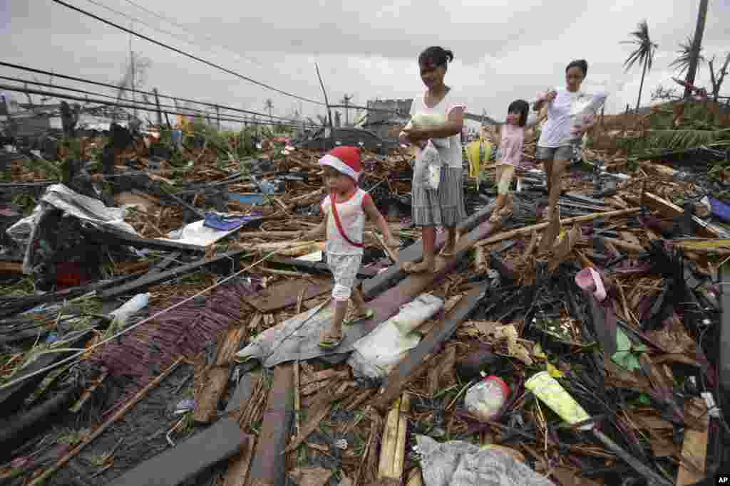 Survivors walk in typhoon ravaged Tacloban city, Nov. 12, 2013.