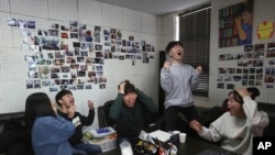 Film club members celebrate as they watch a TV live broadcasting of South Korean director Bong Joon Ho's "Parasite" receiving the award for best picture at the Oscars, at the Yeonsei University in Seoul, South Korea, Feb. 10, 2020.