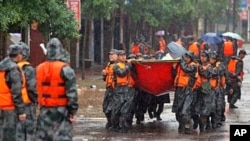 Chinese rescuers carry their boats in to evacuate residents in Fuzhou, Jiangxi province, 24 Jun 2010