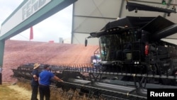 Farmers look at a large grain harvester during the Agrishow farm equipment fair in Ribeirao Preto, Brazil, May 1, 2019. (REUTERS/Marcelo Teixeira)