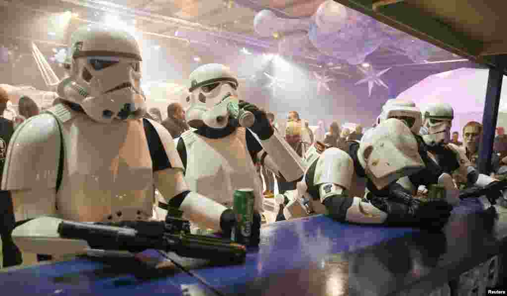 People dressed as Storm Troopers stand at a bar as they pose for a photograph holding cans of beer at the &quot;For The Love of The Force&quot; Star Wars fan convention in Manchester, northern England.