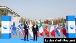 Perdana Menteri Yunani Kyriakos Mitsotakis berbicara dengan Perdana Menteri Italia Mario Draghi menjelang KTT negara-negara Mediterania MED7 ke-8 di Athena, Yunani, 17 September 2021. (Foto: REUTERS/Louiza Vradi)