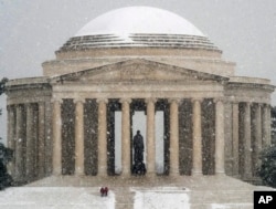 Visitors to the Jefferson Memorial in Washington, walk down the front steps on a snowy Presidents Day moliday in the Nation's Capital, Feb. 15, 2016.