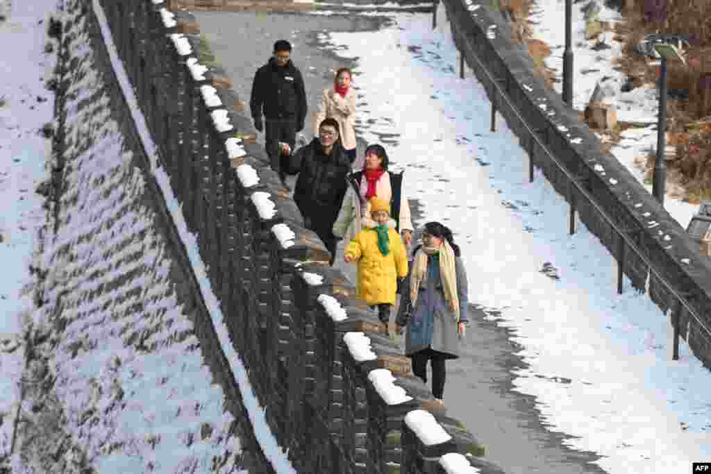 دیوار چین پر چہل قدمی کرتے سیاح جنہوں نے موسم کی سختی سے بچنے کے لیے گرم کپڑے پہنے ہوئے ہیں۔&nbsp;&nbsp; &nbsp;