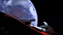 Space -- This still image taken from a SpaceX livestream video shows "Starman" sitting in SpaceX CEO Elon Musk's cherry red Tesla roadster after the Falcon Heavy rocket delivered it into orbit around the Earth on 6Feb2018.