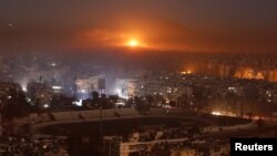 Llamas y humo iluminan el cielo sobre la asediada ciudad de Alepo, ahora controlada en su mayoría por las tropas del gobierno sirio y los milicianos.