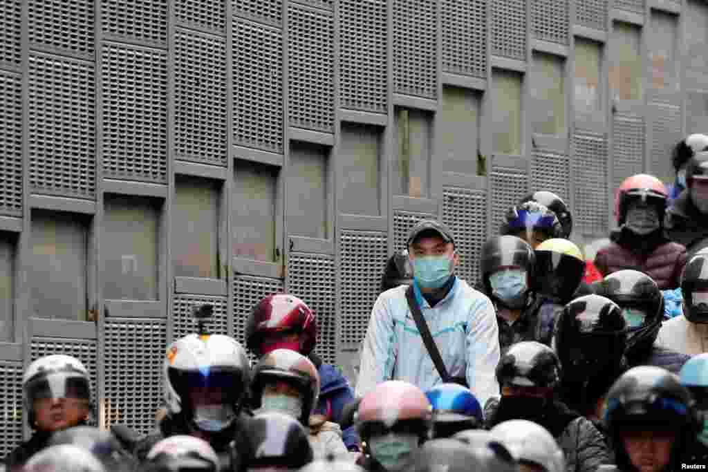 Un motociclista usa una máscara facial para protegerse de la enfermedad durante el tráfico a la hora pico de la mañana en Taipei, Taiwán.