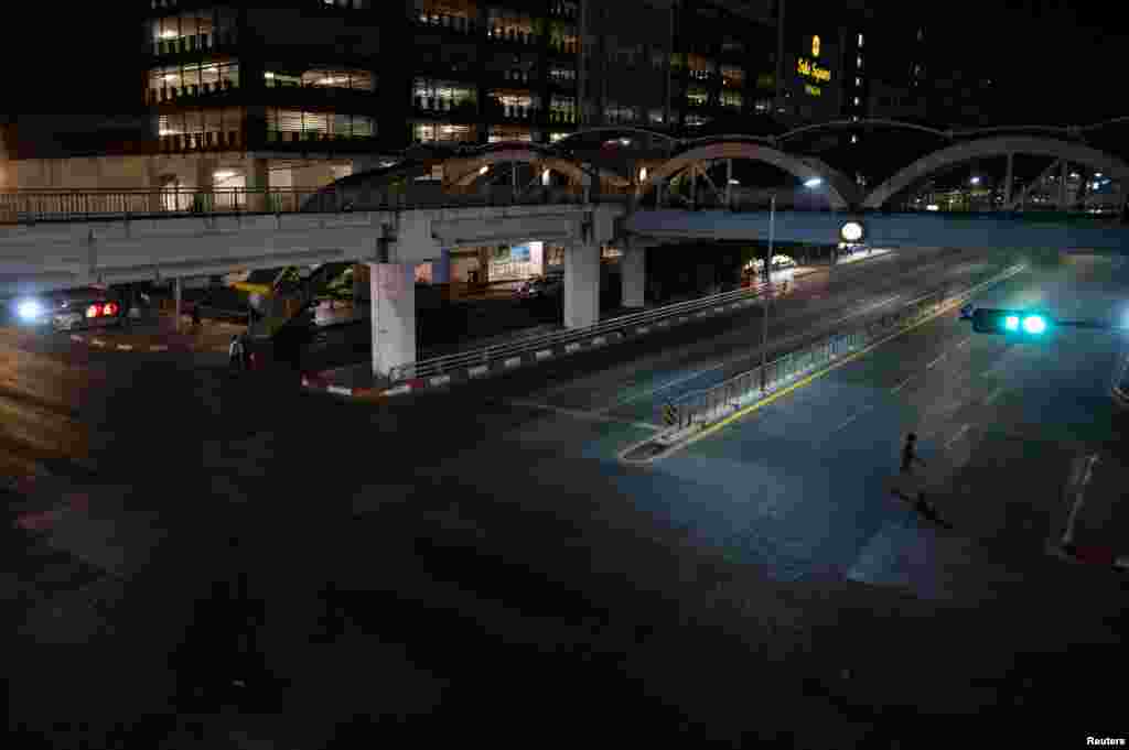 A man crosses an empty street as the New Year countdown celebrations and crowded events were banned amid the spread of the COVID-19 in Yangon, Myanmar, Dec. 31, 2020. 